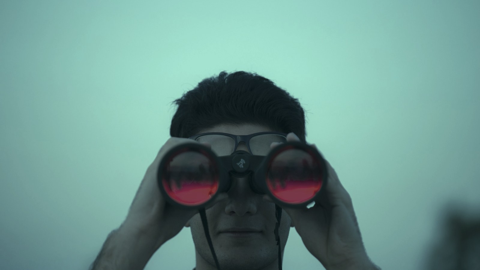Where to find AI talent: a man scanning the distance through red-lensed binoculars